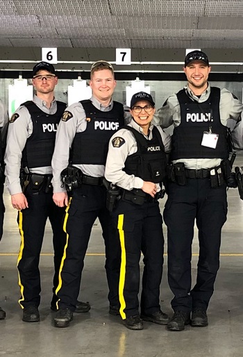 Le caporal Dhesi en uniforme de police avec trois autres policiers.